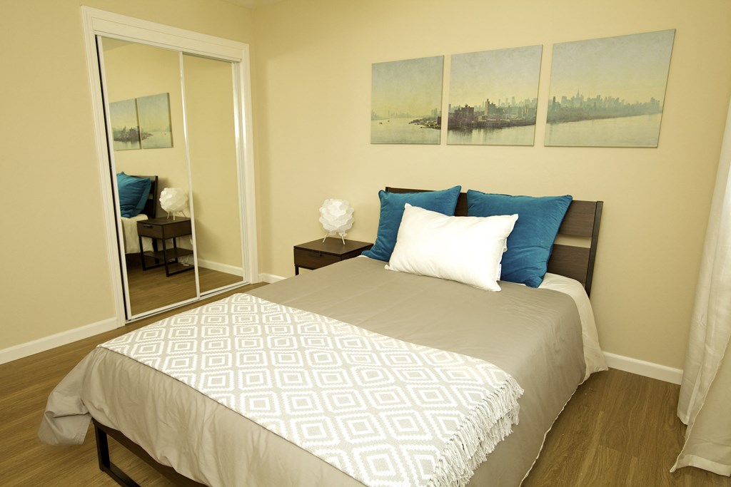 a bedroom with a large bed and a mirror