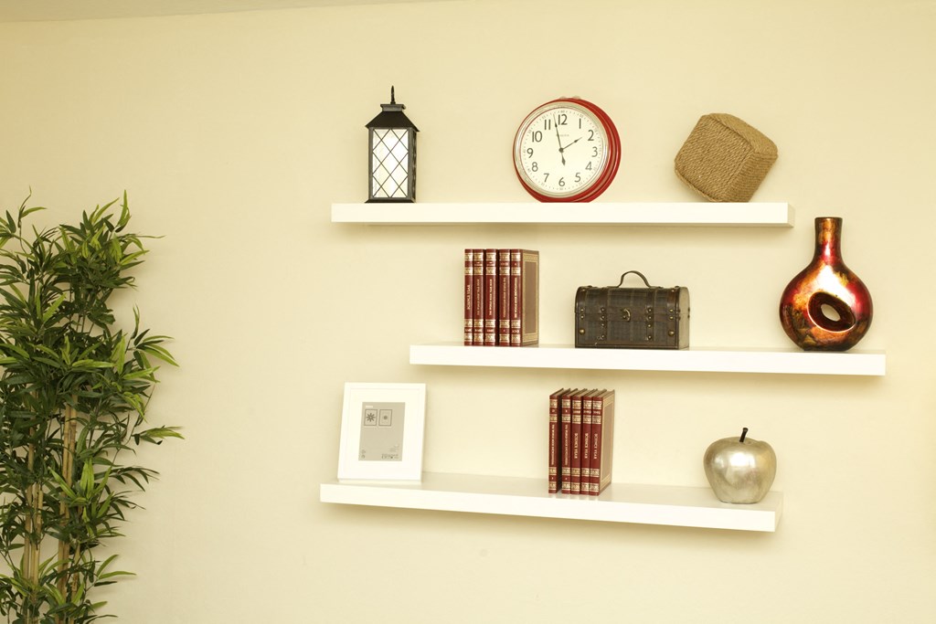 a wall with shelves with various items and a clock