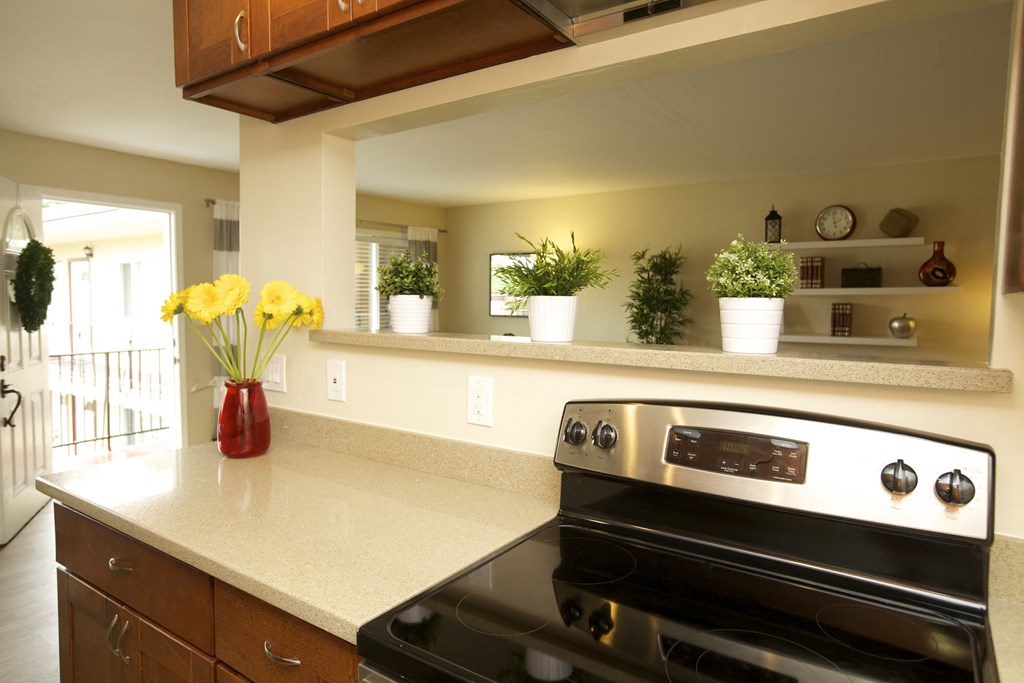 a kitchen with a stove and a counter with flowers