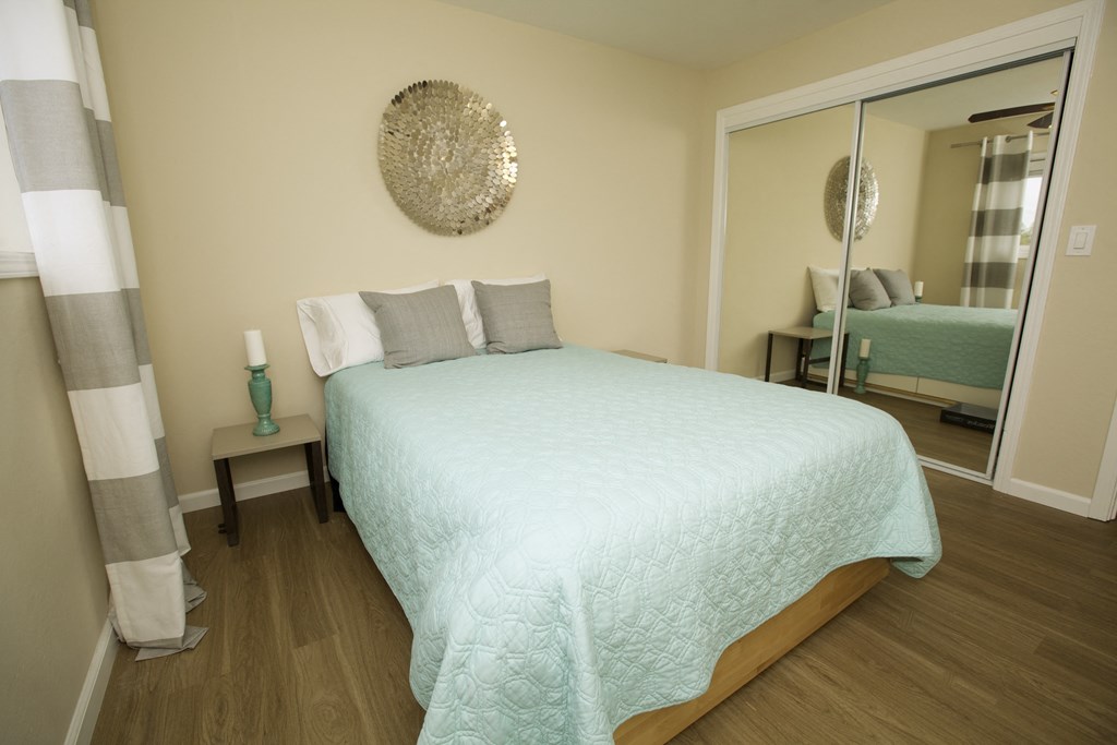 a bedroom with a large bed and a mirror