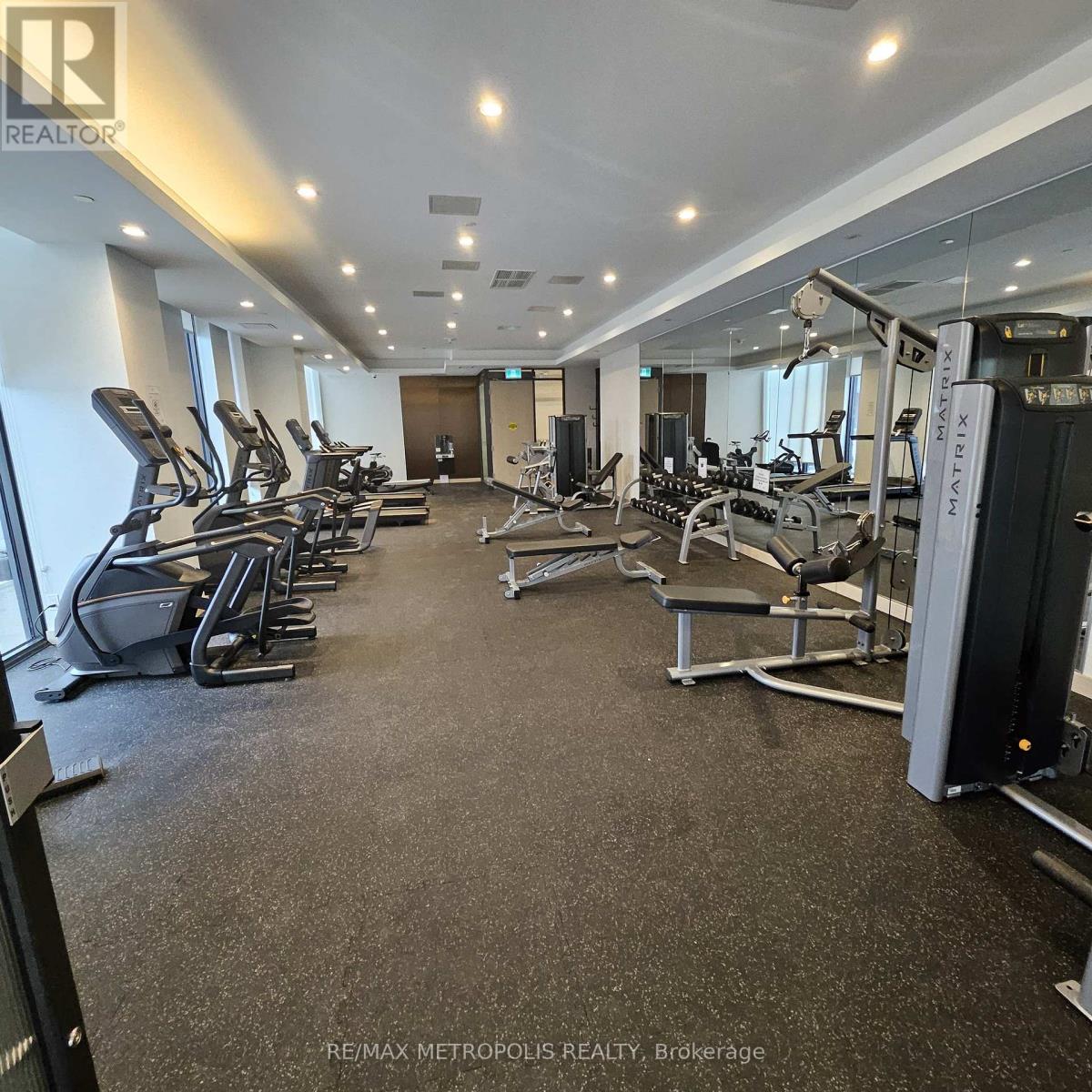 A gym with a variety of equipment including treadmills, weights, and exercise machines.
