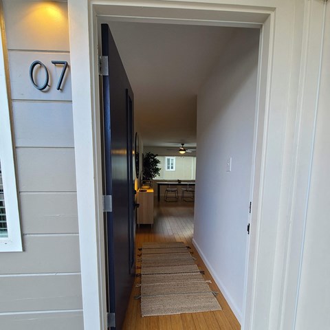 a hallway with a door open to a kitchen and a dining room