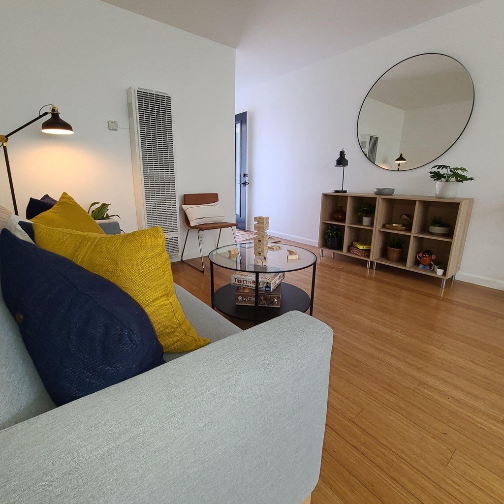 a living room with a couch and a table and a mirror