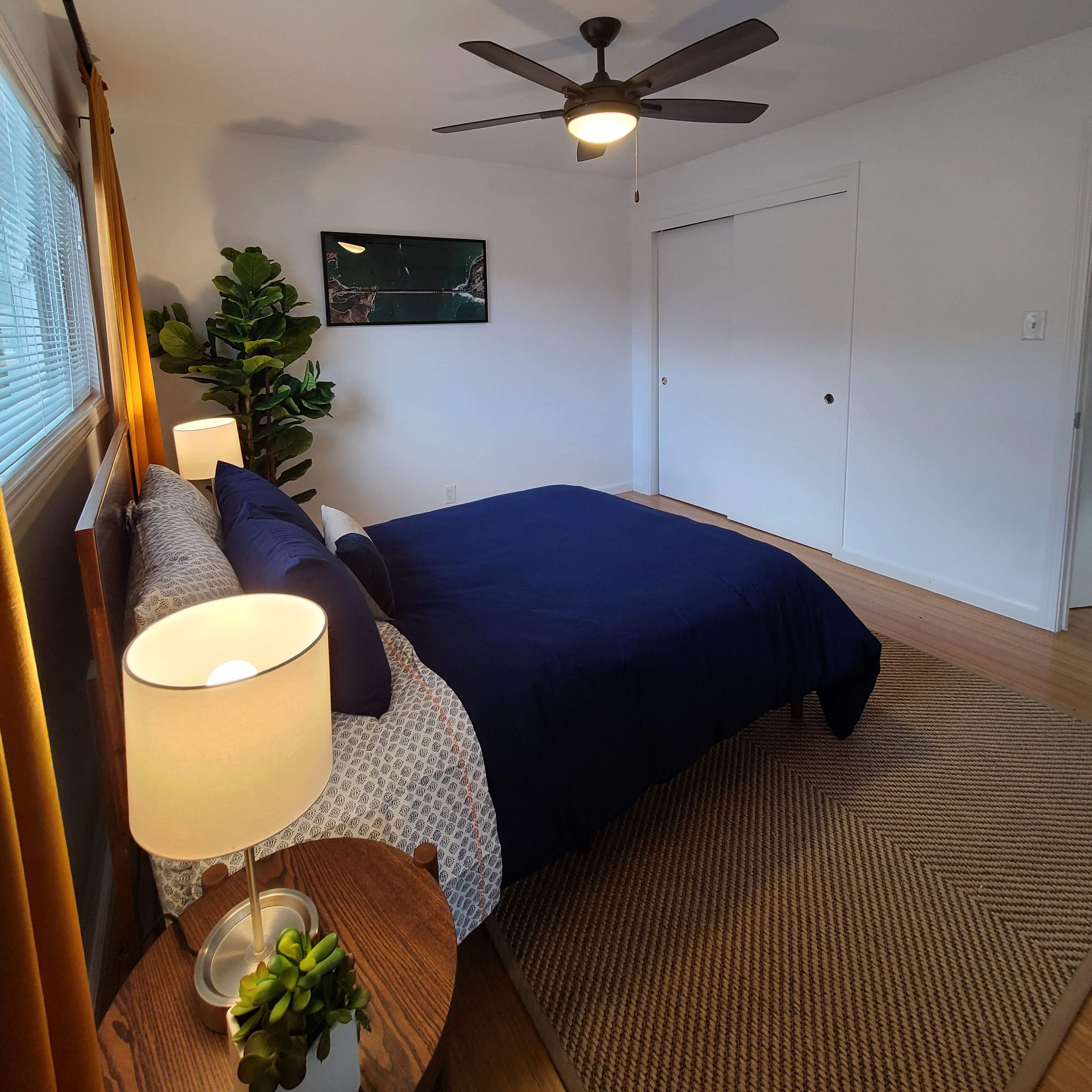 a bedroom with a bed and a ceiling fan