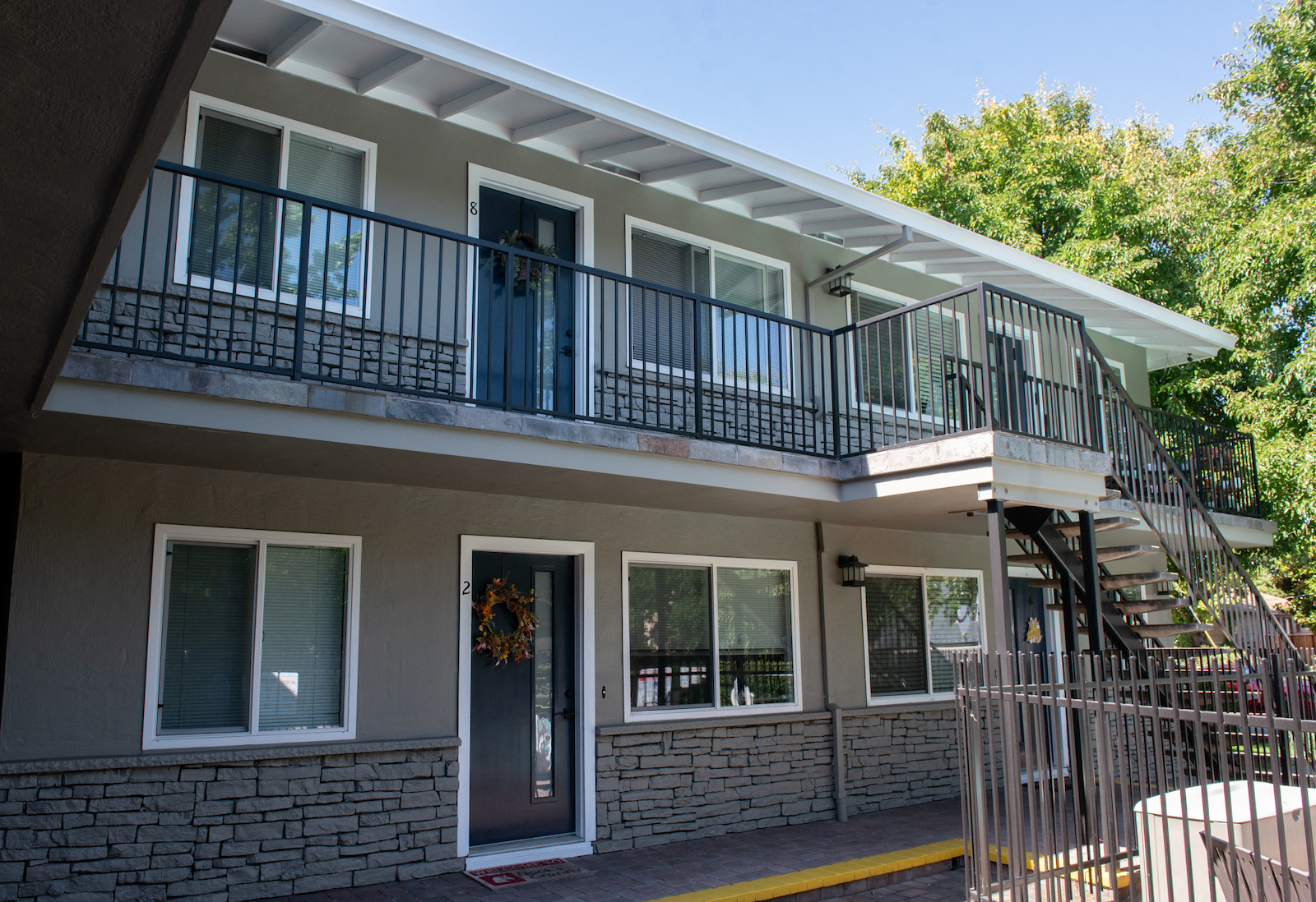 the front of a building with a balcony and a staircase