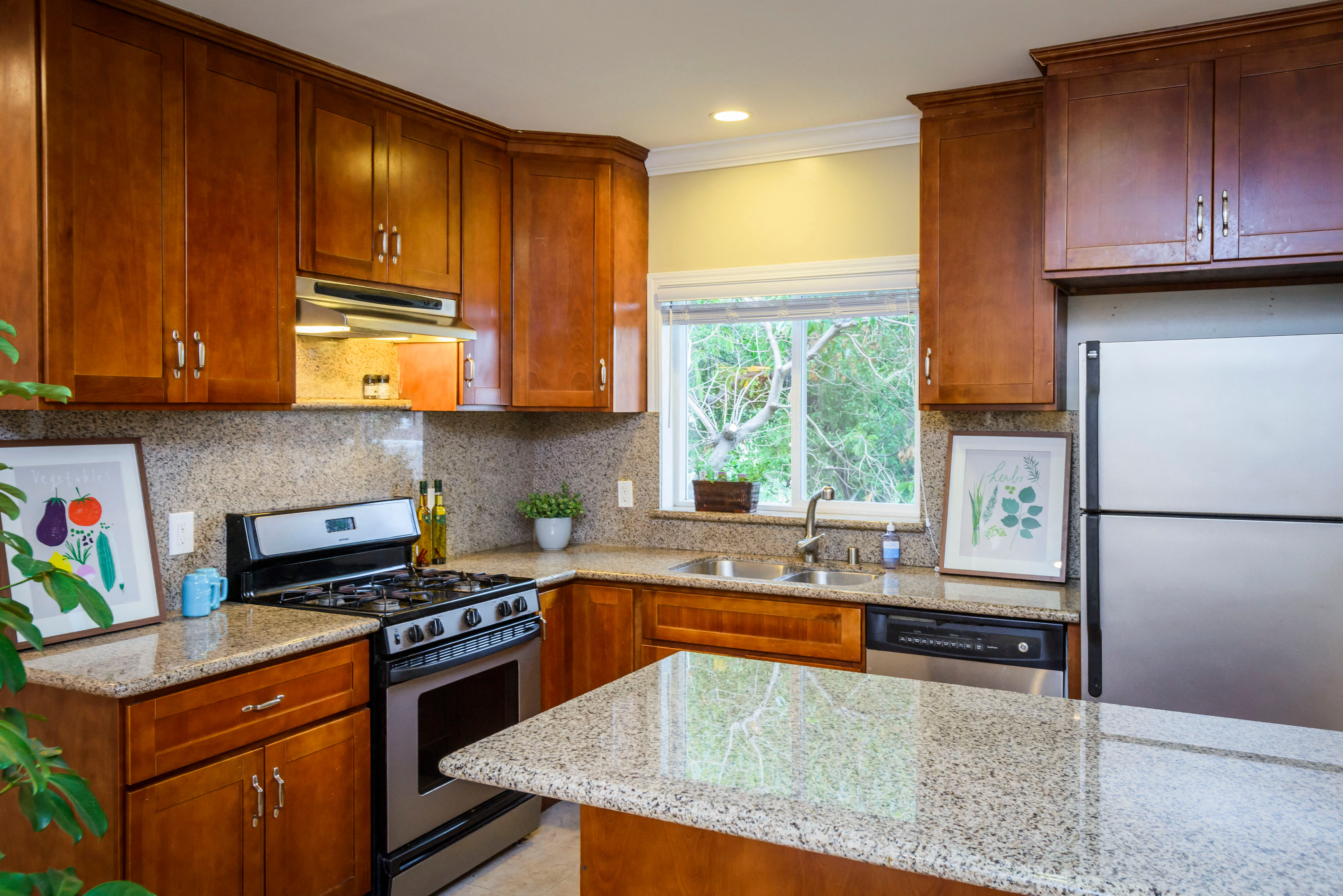 a kitchen with granite counter tops and wooden cabinets