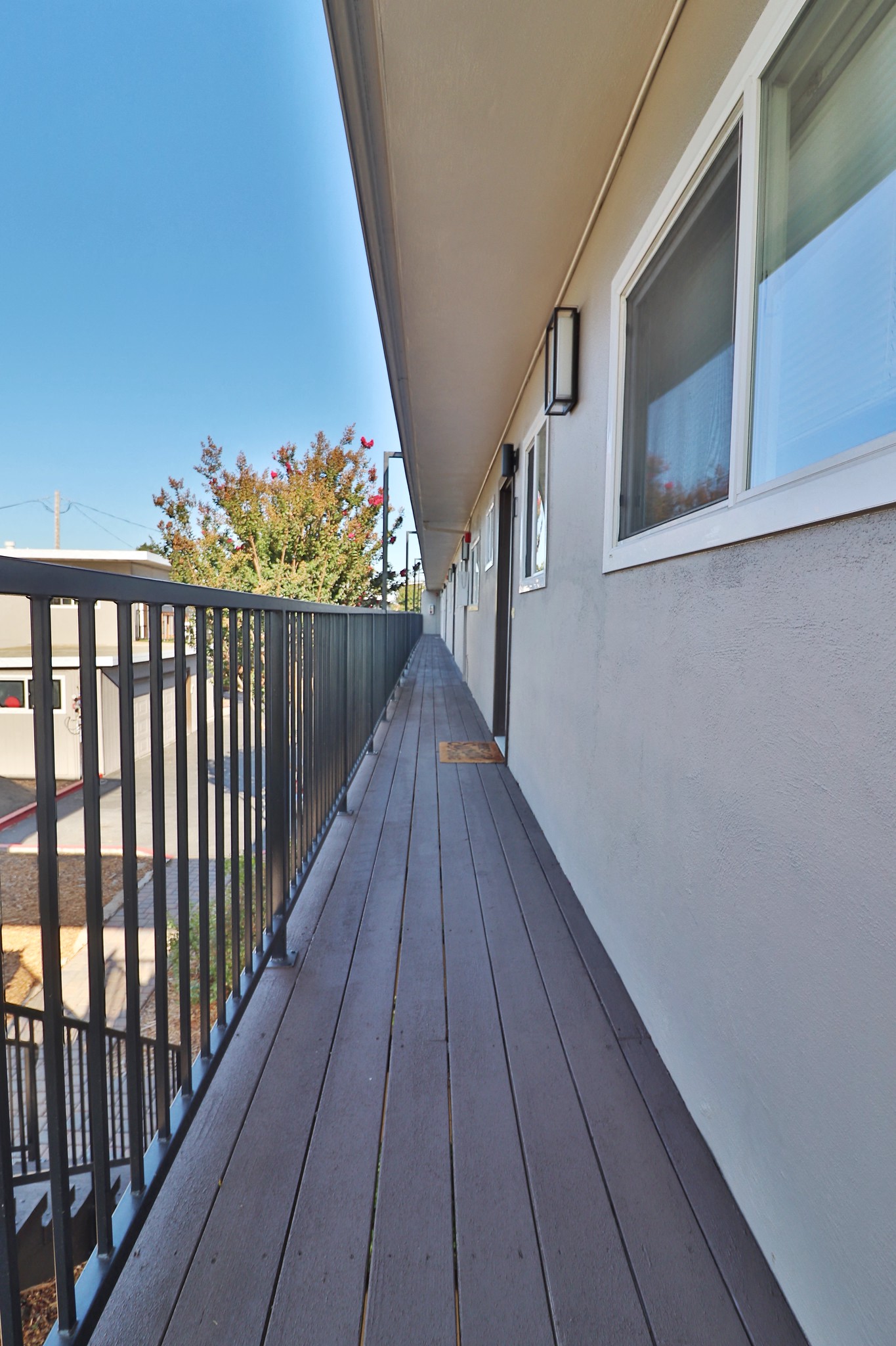 a balcony with a wooden deck and a building on the side