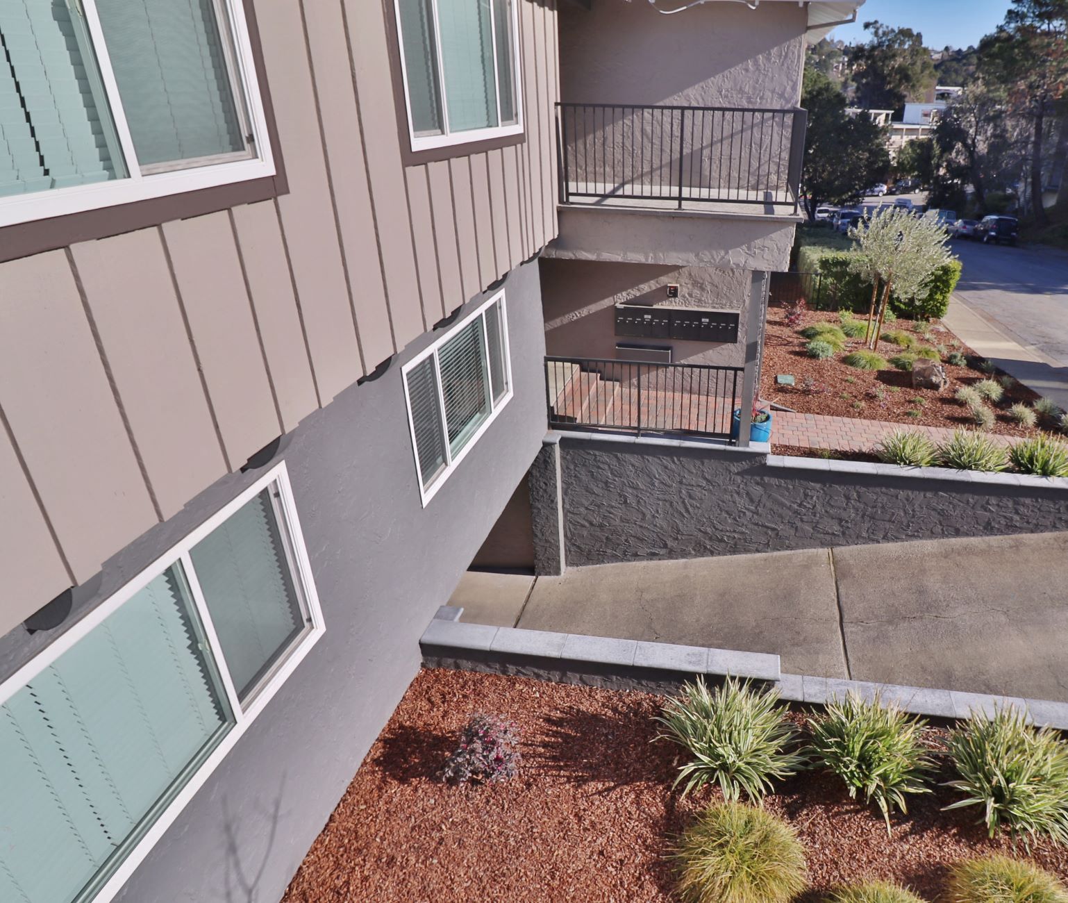 an exterior view of a building with stairs and a garden