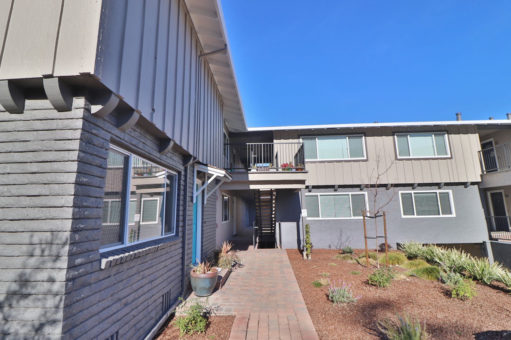 a view of an apartment building with a walkway in front of it