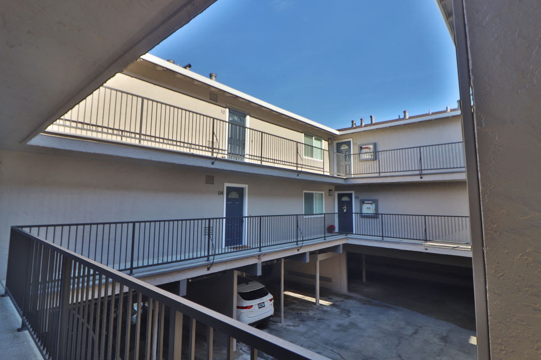 a view of a building with balconies and a parking lot