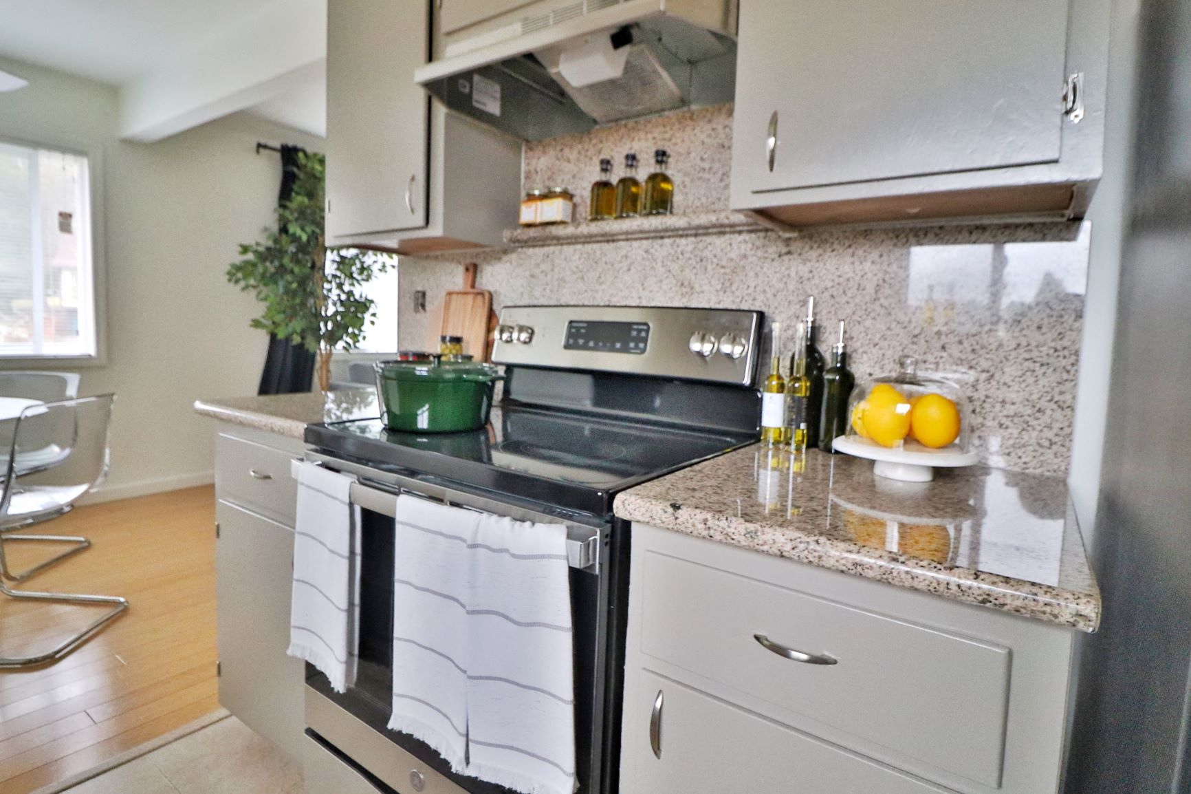 a kitchen with white cabinets and a stove and a sink