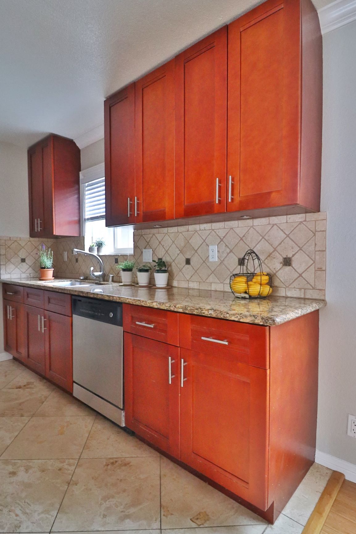 a kitchen with red cabinets and a counter top and a sink