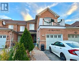 A white car is parked in front of a brick house with a balcony.