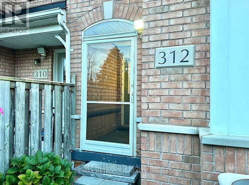A house numbered 312 with a window showing a reflection of a building.