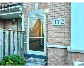 A house numbered 312 with a window showing a reflection of a building.