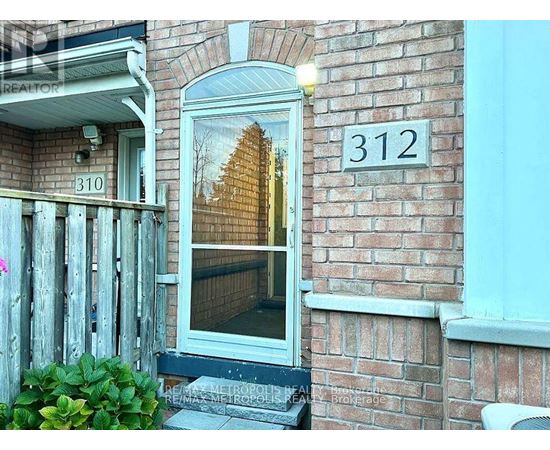 A house numbered 312 with a window showing a reflection of a building.