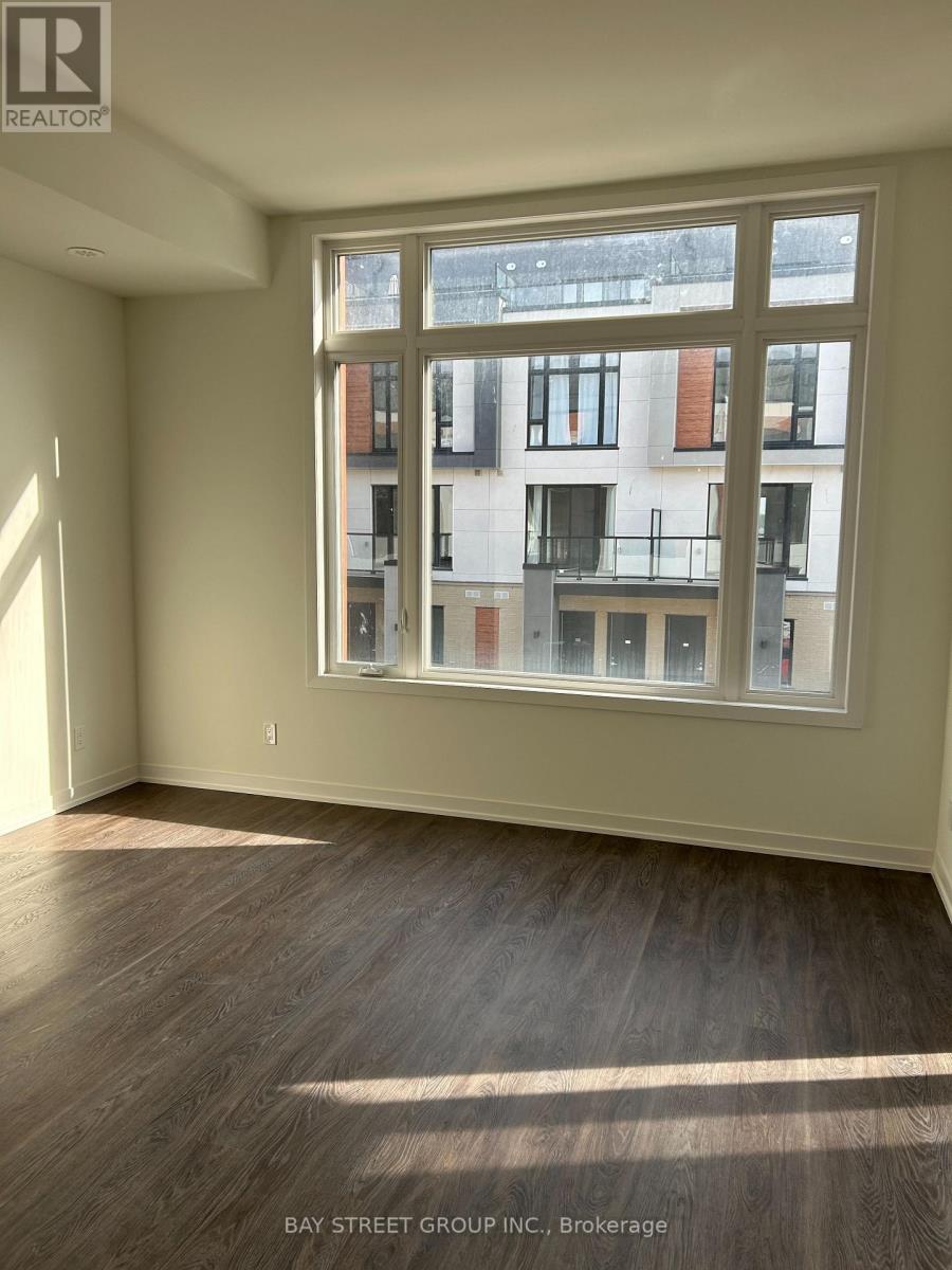A room with a large window showing a view of a building across the street.