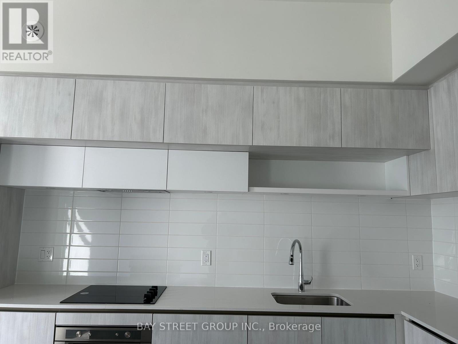 A modern kitchen with a stove top oven and a sink.