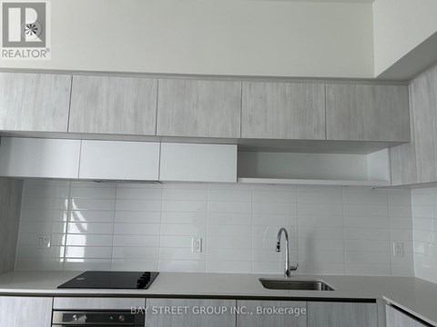 A modern kitchen with a stove top oven and a sink.