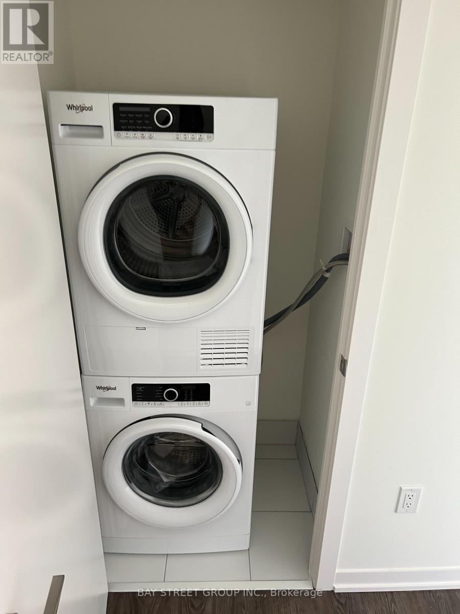 A white Whirlpool washing machine and dryer in a small laundry room.