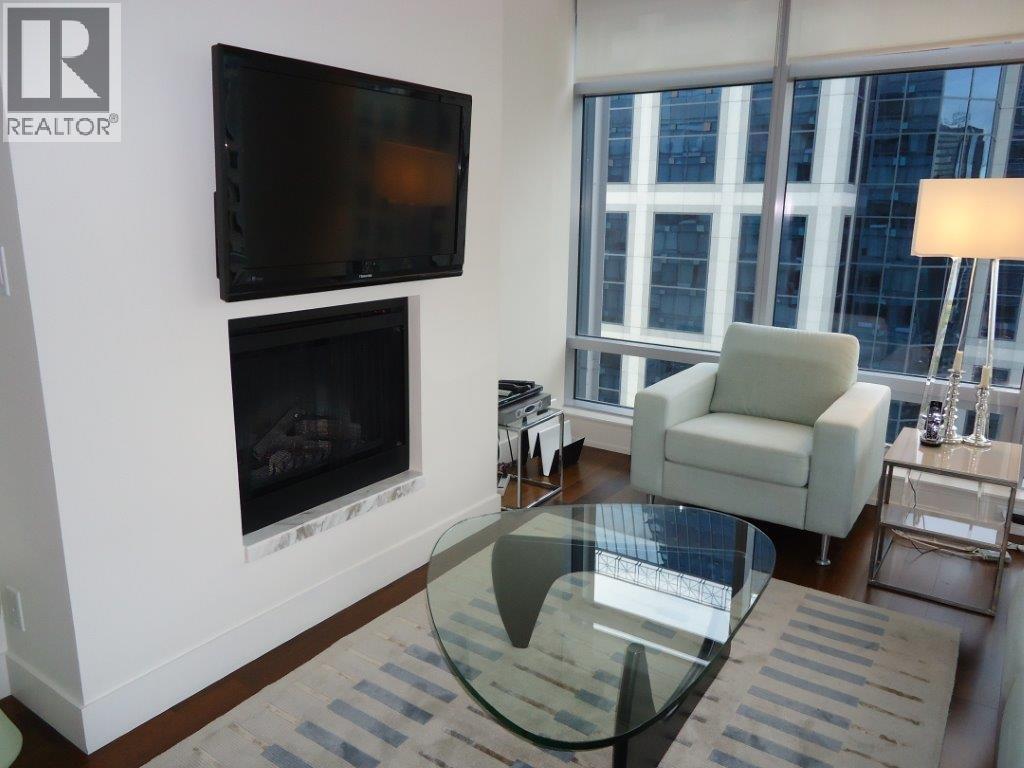 A living room with a fireplace, a chair, and a television.
