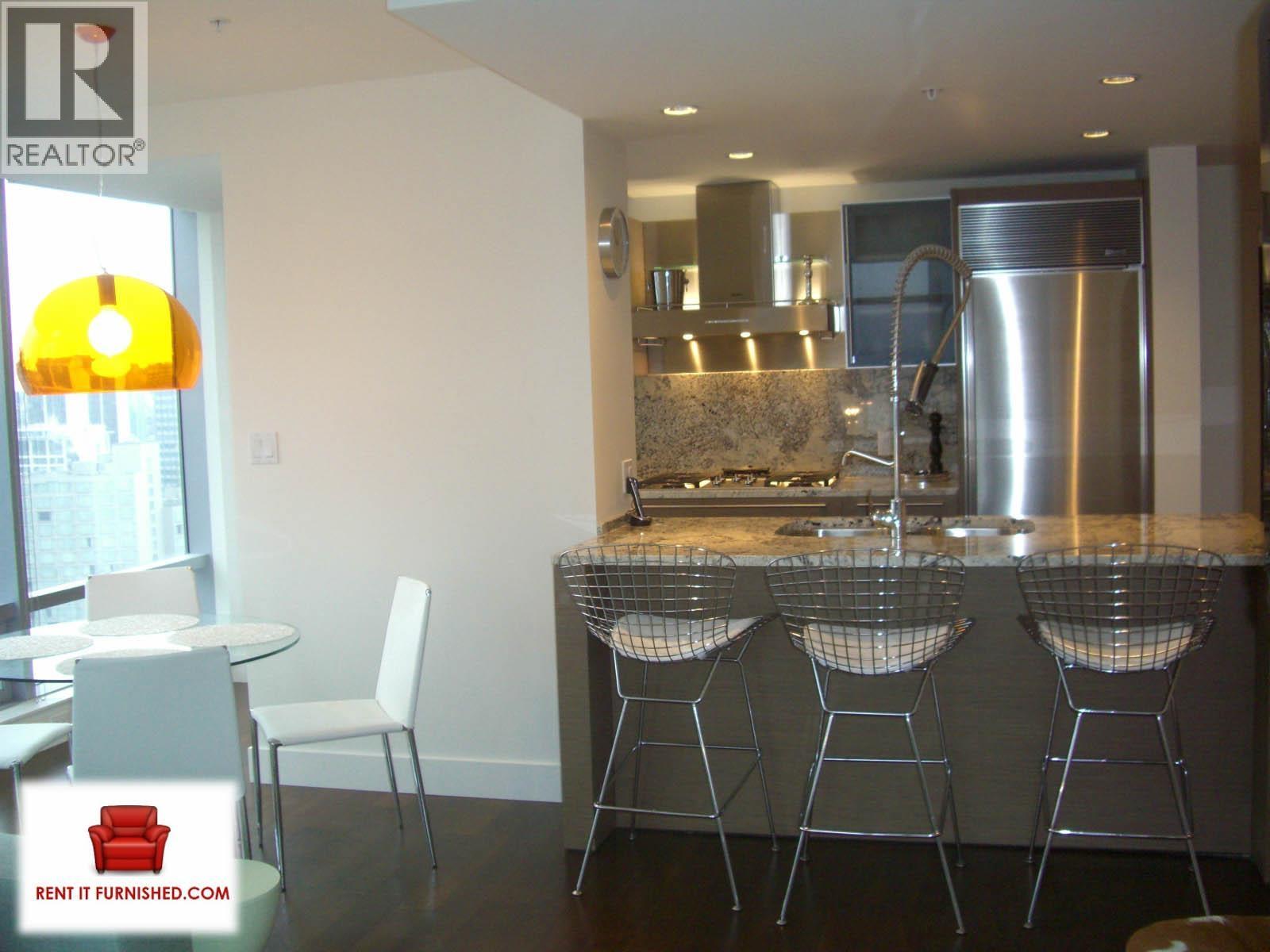 A kitchen with a table and chairs.