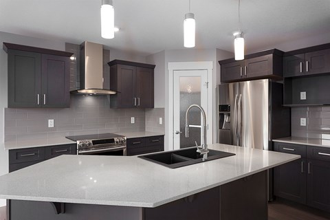 A modern kitchen with dark brown cabinets and a white countertop.