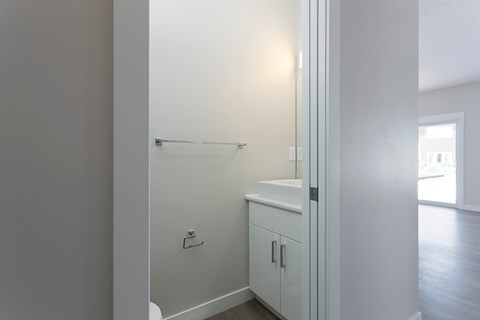 A white bathroom with a sink and a towel rack.
