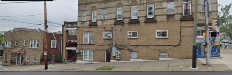 A street view of a row of buildings with a mural on the side of one of them.