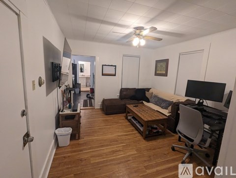 A living room with a brown couch and a white chair.