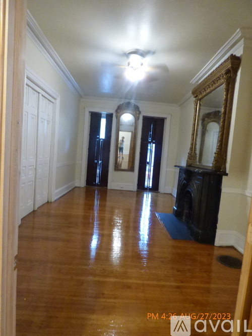 A large empty room with wood floors and a fireplace.