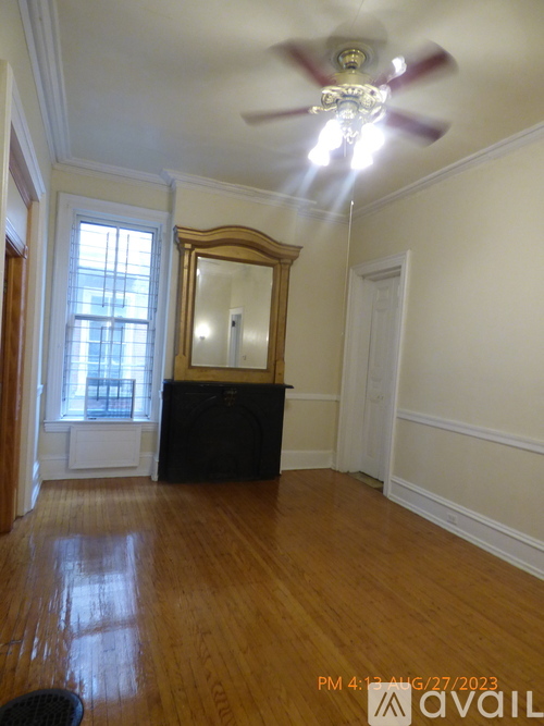 A room with a ceiling fan and a large mirror.