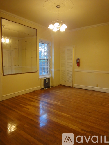 A room with wooden floors and a large mirror on the wall.
