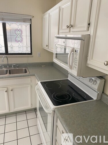 A kitchen with white appliances and cabinets.