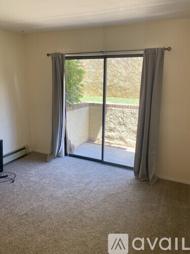 A room with a sliding glass door leading to a backyard.