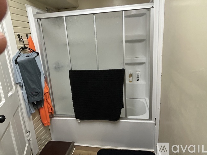 A black towel is hanging on a white door.