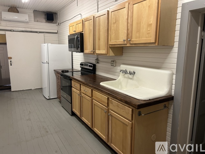 A kitchen with wooden cabinets and a white sink.