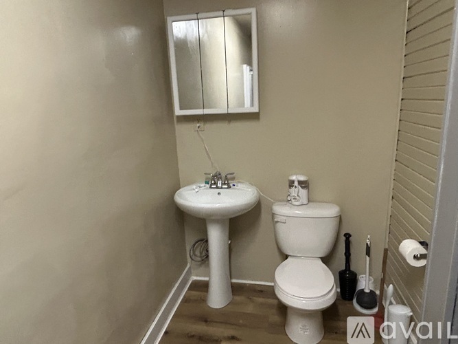 A white toilet sits next to a sink in a small bathroom.