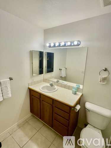 A bathroom with a sink, mirror, and toilet.