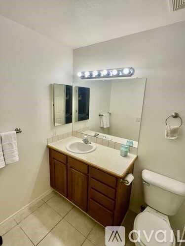 A bathroom with a sink, mirror, and toilet.