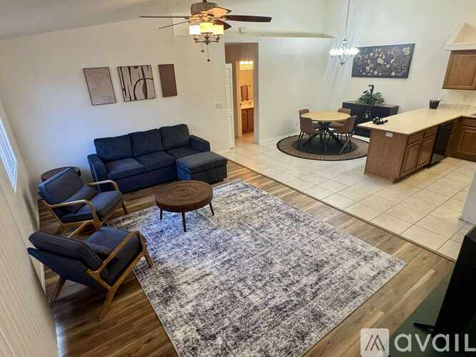 A living room with a blue couch and a rug.