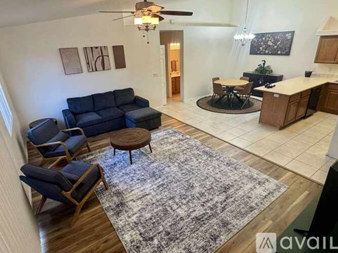 A living room with a blue couch and a rug.
