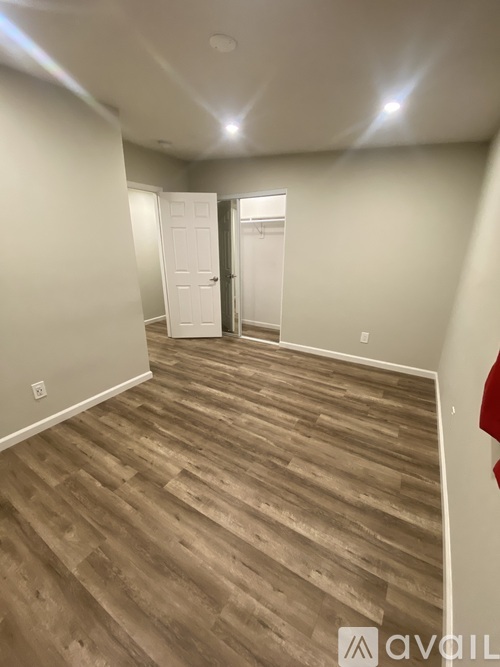 A room with wooden flooring and white walls.