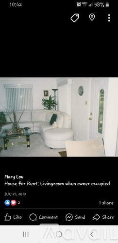 A living room with a white couch and a glass coffee table.