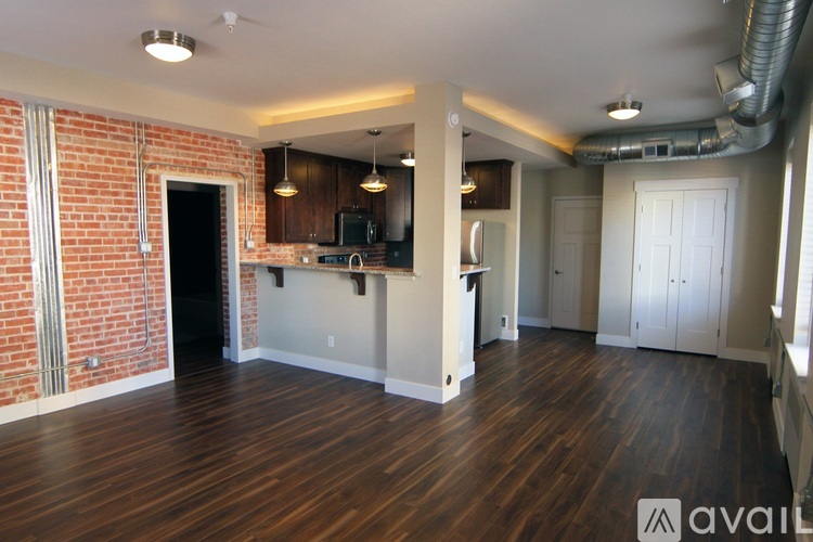 A large open space with wooden floors and a brick wall.