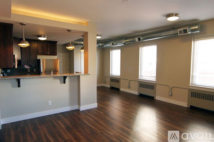 A kitchen with wooden floors and a bar area.