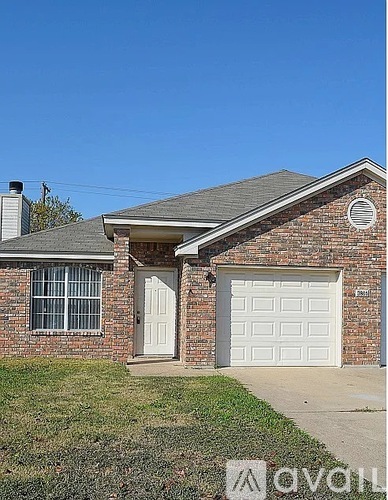 A house with a white garage door and a brick facade.