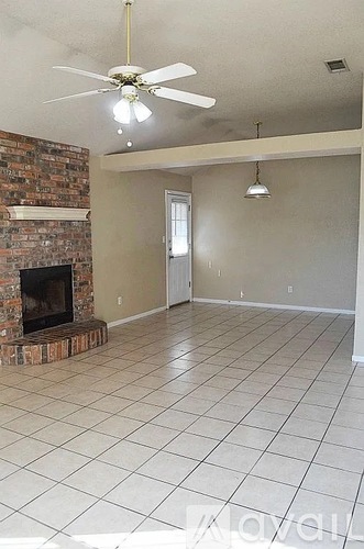 A living room with a fireplace and a ceiling fan.