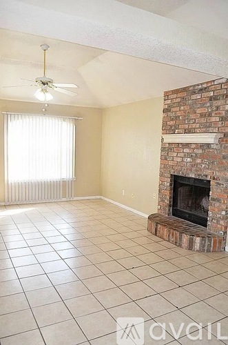 A living room with a fireplace and a ceiling fan.