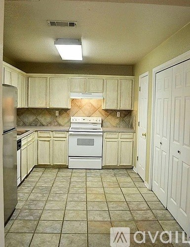 A kitchen with white appliances and cabinets.